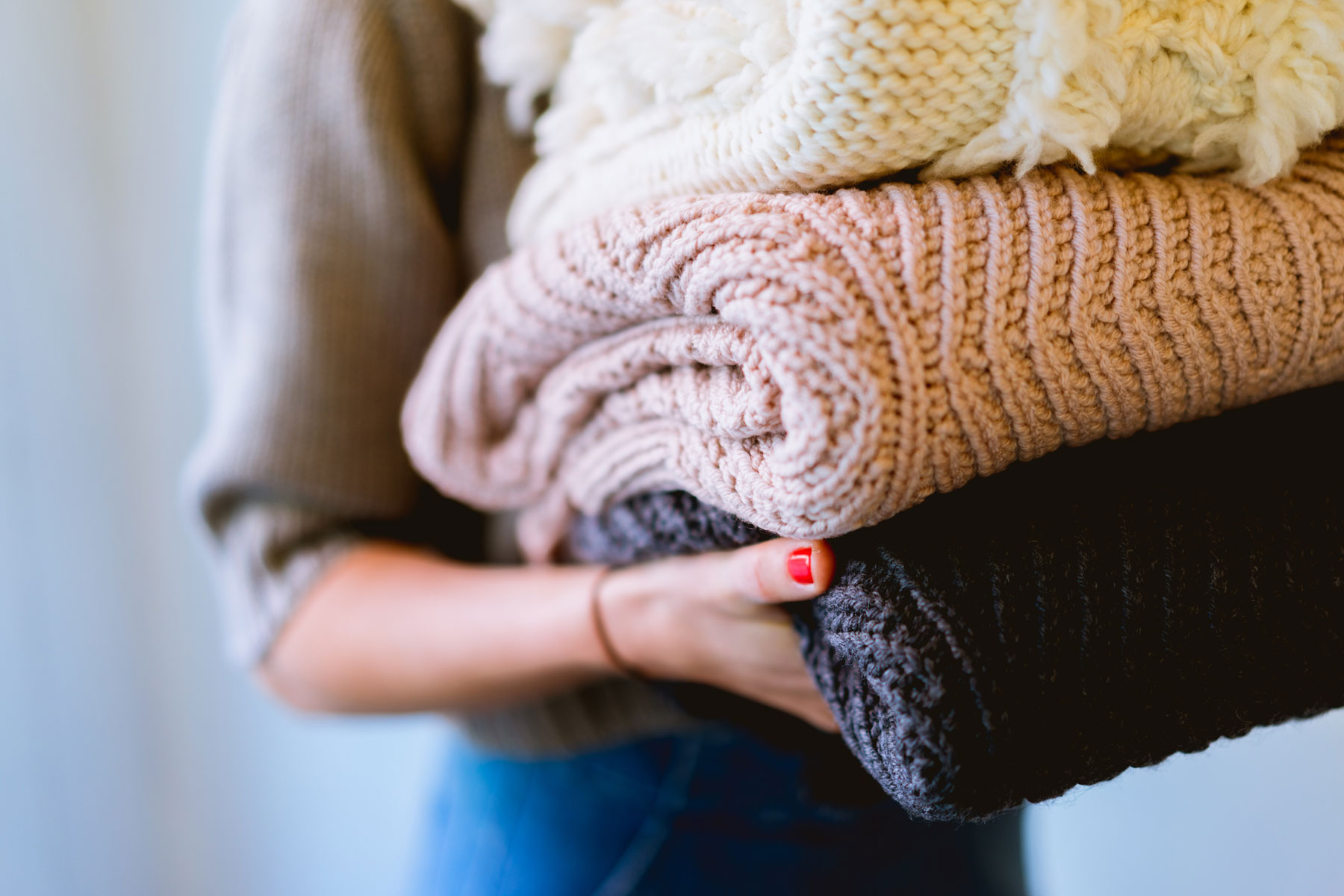 Close up of a woman carrying folded blankets